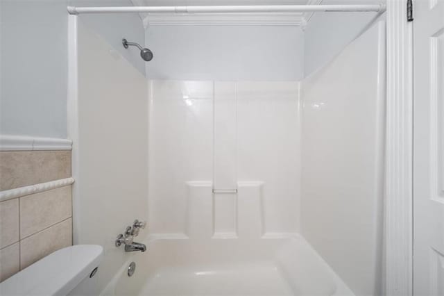 bathroom featuring toilet, tile walls, and shower / bathtub combination