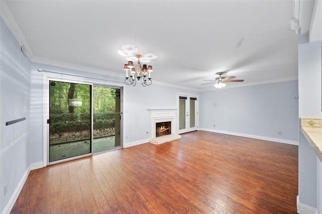 unfurnished living room featuring crown molding, ceiling fan with notable chandelier, and dark hardwood / wood-style flooring