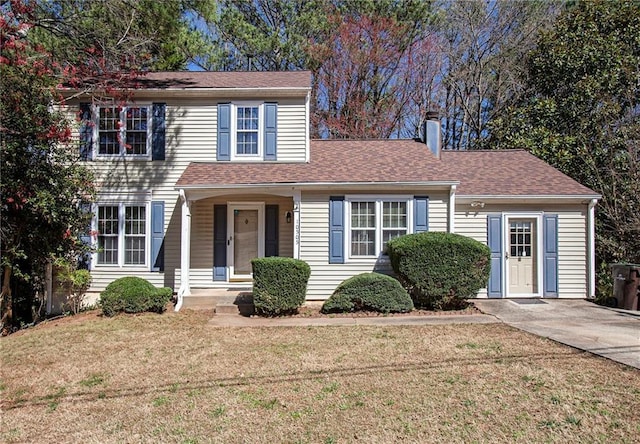 view of front of property featuring a shingled roof and a front lawn