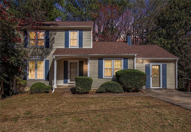 traditional-style home featuring a front yard and roof with shingles