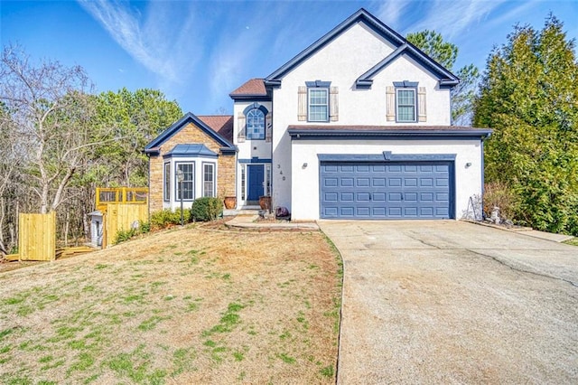 view of front of home with a garage, fence, driveway, and stucco siding