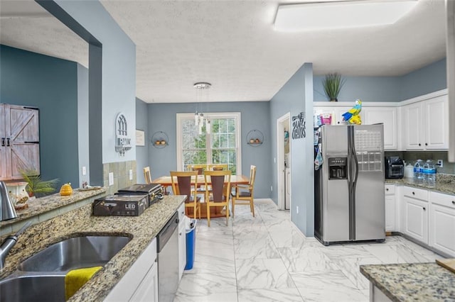 kitchen featuring white cabinetry, marble finish floor, appliances with stainless steel finishes, and a sink