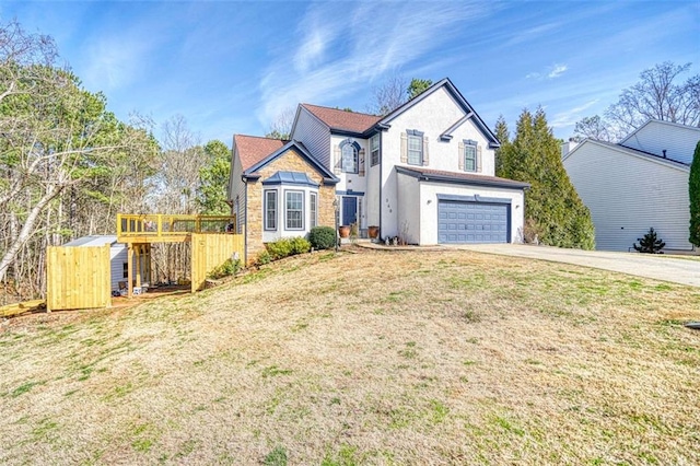 traditional-style house with concrete driveway, an attached garage, fence, and a front lawn