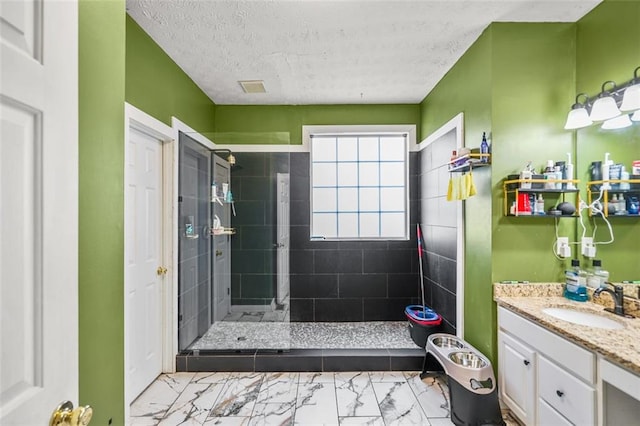 bathroom featuring vanity, a shower stall, marble finish floor, and a textured ceiling