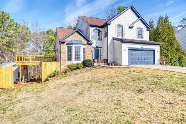 traditional home featuring an attached garage, concrete driveway, and a front yard