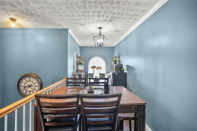 dining room with a notable chandelier, a textured ceiling, and crown molding