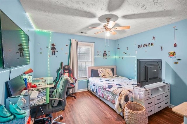 bedroom featuring a textured ceiling, a ceiling fan, and wood finished floors