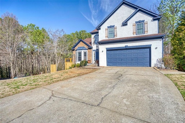 traditional-style house featuring stucco siding, driveway, a front yard, and a garage