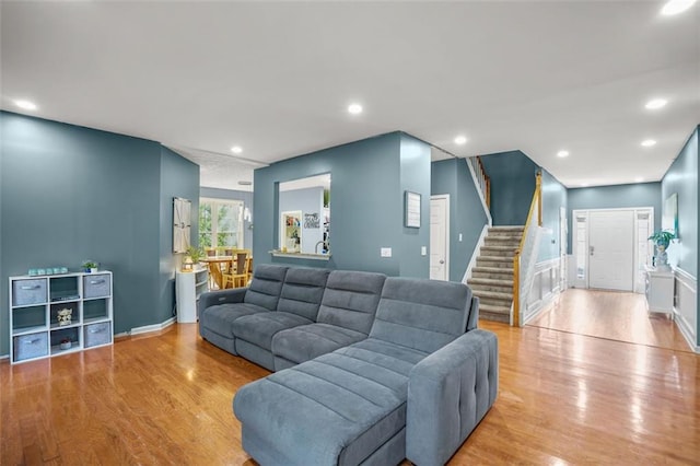 living room with stairs, recessed lighting, and wood finished floors