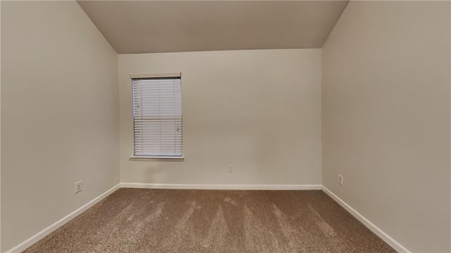 spare room with vaulted ceiling and carpet floors