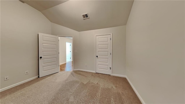 unfurnished bedroom with lofted ceiling and light carpet