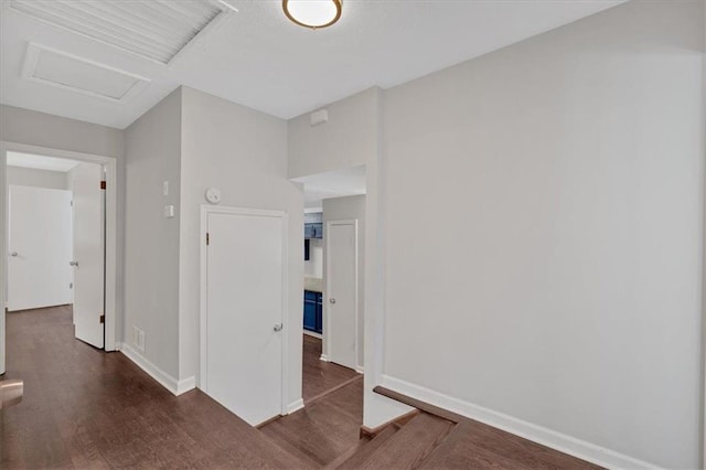 spare room with baseboards, visible vents, wood finished floors, and attic access