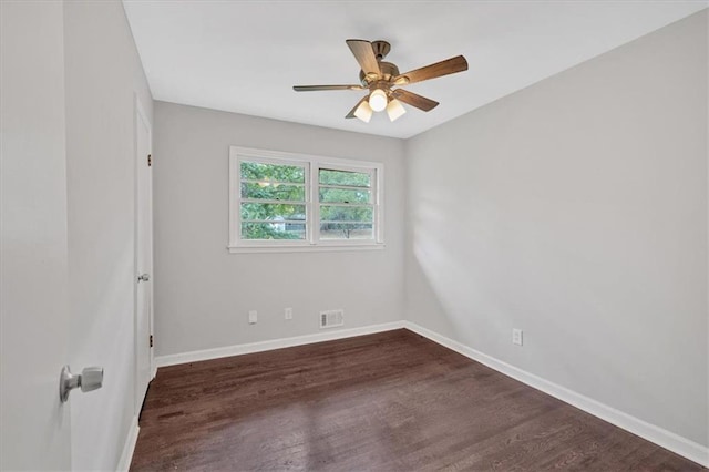 spare room featuring visible vents, dark wood finished floors, ceiling fan, and baseboards