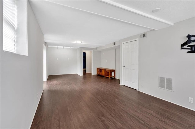 unfurnished living room featuring baseboards, dark wood-style floors, and visible vents