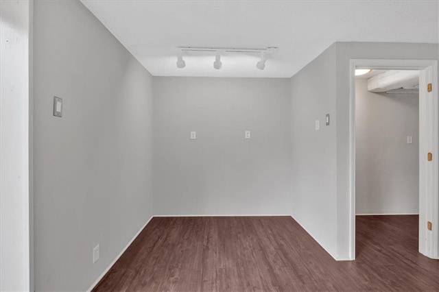 unfurnished room featuring rail lighting and wood finished floors