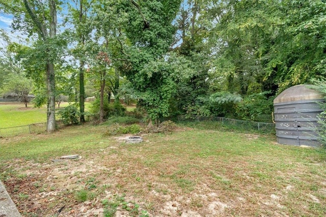 view of yard featuring an outdoor fire pit and fence