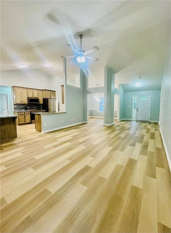 7675 Lanier View Rdg, Cumming, GA 30041 - unfurnished living room featuring vaulted ceiling, a ceiling fan, light wood-style floors, and baseboards
