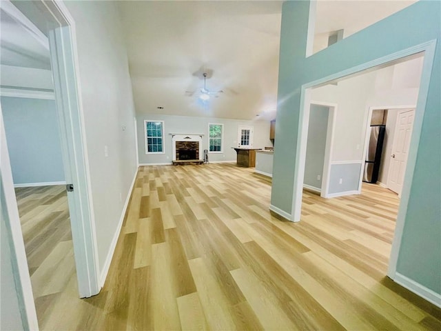 7675 Lanier View Rdg, Cumming, GA 30041 - unfurnished living room featuring light wood finished floors, a ceiling fan, baseboards, and a fireplace with raised hearth