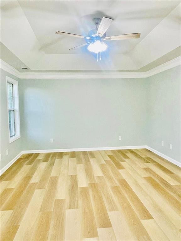 7675 Lanier View Rdg, Cumming, GA 30041 - spare room featuring a tray ceiling, light wood-style floors, a ceiling fan, baseboards, and ornamental molding