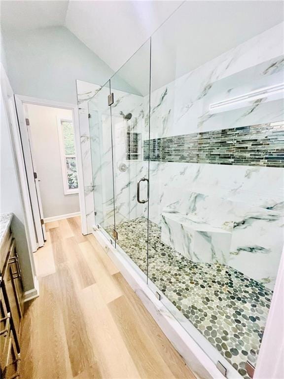 7675 Lanier View Rdg, Cumming, GA 30041 - full bathroom with wood finished floors, vaulted ceiling, and a marble finish shower