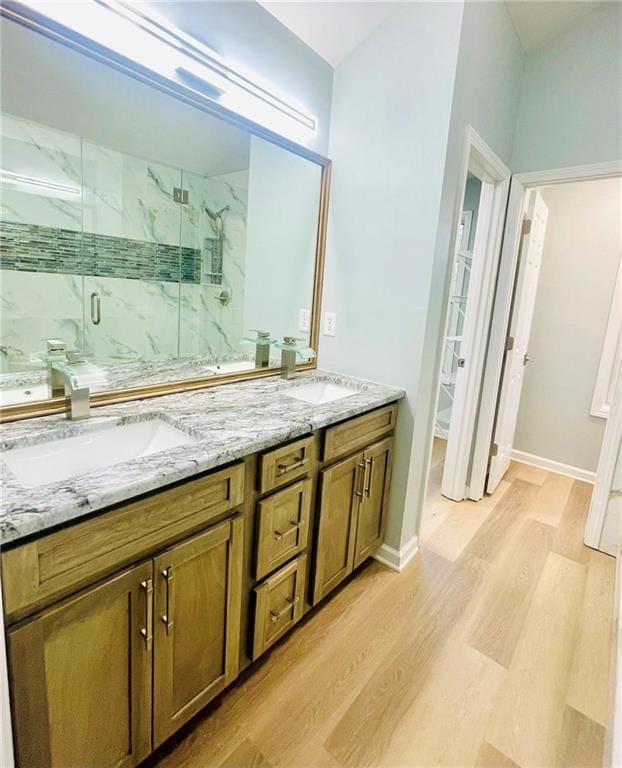 7675 Lanier View Rdg, Cumming, GA 30041 - bathroom featuring wood finished floors, a marble finish shower, and double vanity