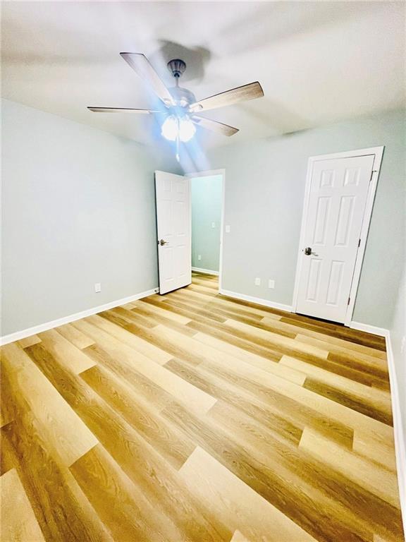 7675 Lanier View Rdg, Cumming, GA 30041 - unfurnished bedroom featuring baseboards, light wood-style flooring, and ceiling fan