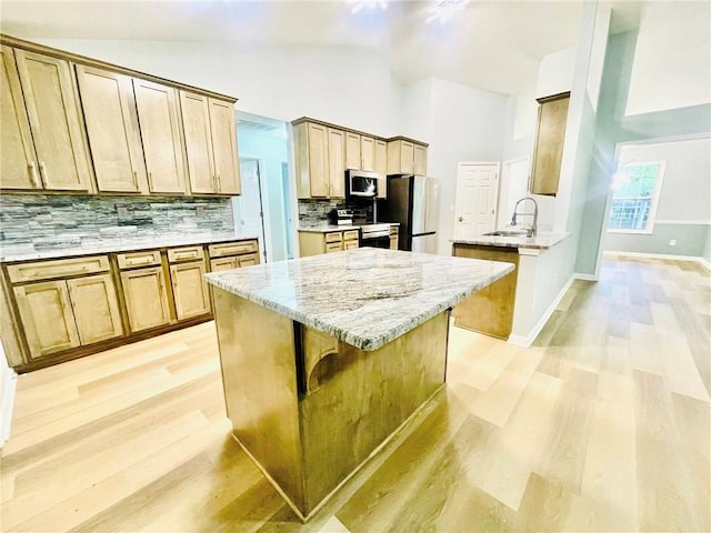 7675 Lanier View Rdg, Cumming, GA 30041 - kitchen with a sink, stainless steel appliances, light wood finished floors, decorative backsplash, and light stone counters