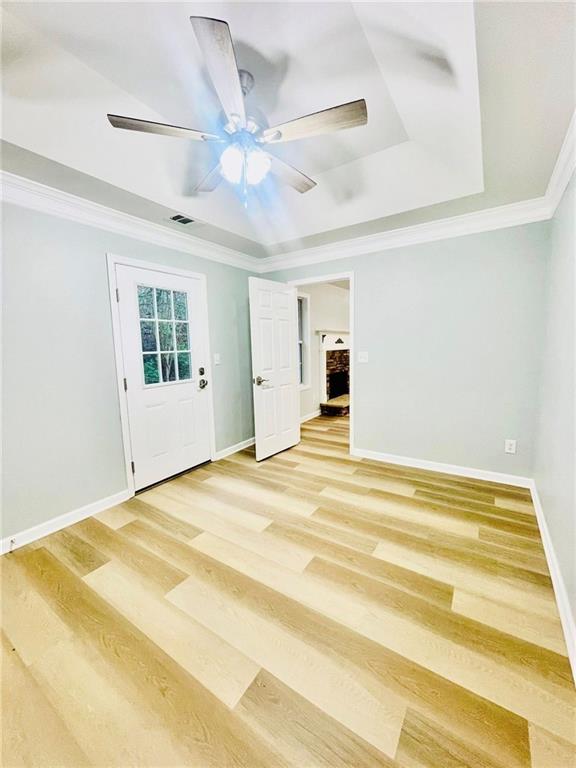 7675 Lanier View Rdg, Cumming, GA 30041 - unfurnished room featuring ornamental molding, light wood-type flooring, a ceiling fan, baseboards, and a tray ceiling