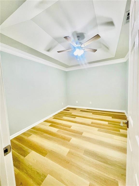 7675 Lanier View Rdg, Cumming, GA 30041 - spare room featuring a tray ceiling, ceiling fan, wood finished floors, ornamental molding, and baseboards