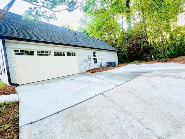 7675 Lanier View Rdg, Cumming, GA 30041 - view of side of home with roof with shingles, central AC, a garage, and concrete driveway