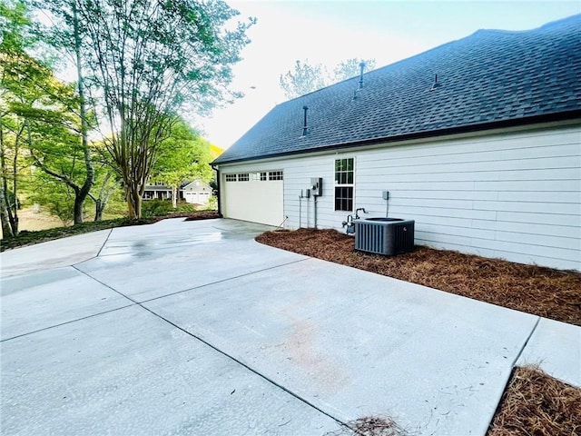 7675 Lanier View Rdg, Cumming, GA 30041 - back of property featuring central AC unit, driveway, and a shingled roof