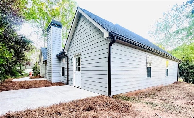 7675 Lanier View Rdg, Cumming, GA 30041 - view of home's exterior with a chimney and a patio area