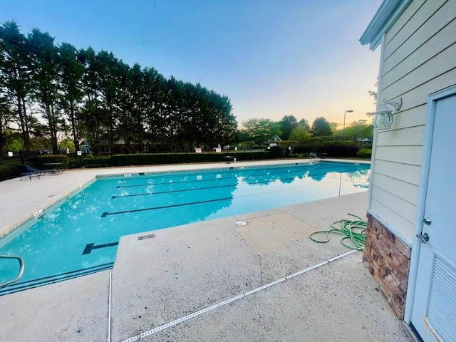 7675 Lanier View Rdg, Cumming, GA 30041 - pool at dusk with a community pool and a patio