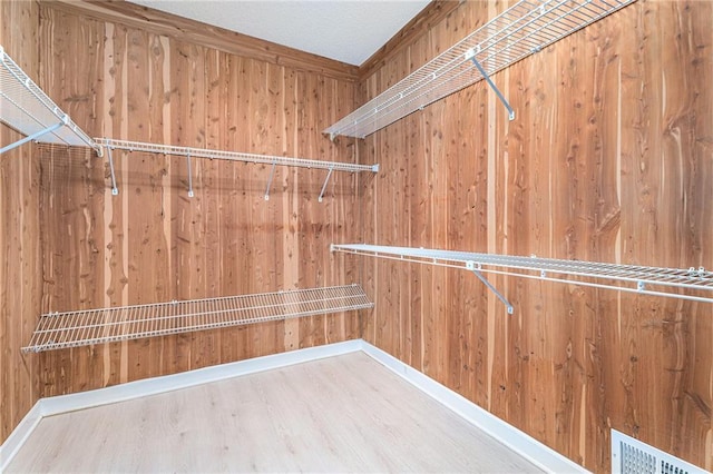 spacious closet featuring visible vents and wood finished floors