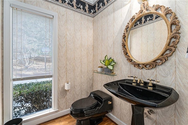 half bathroom featuring plenty of natural light and wallpapered walls