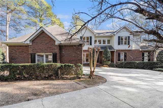 traditional-style house featuring concrete driveway and brick siding