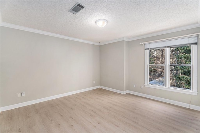 spare room featuring baseboards, light wood-style flooring, visible vents, and crown molding