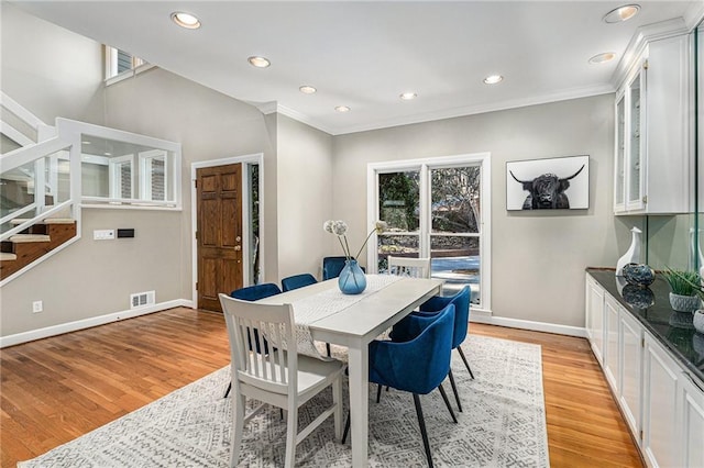 dining room with light wood-style flooring, recessed lighting, visible vents, baseboards, and stairs