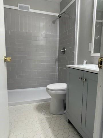 bathroom with toilet, visible vents, a shower stall, and vanity