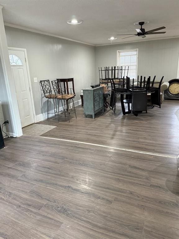 dining area with a ceiling fan, baseboards, ornamental molding, and wood finished floors