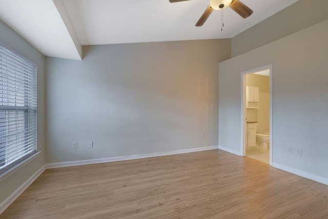 empty room featuring ceiling fan, vaulted ceiling, and light hardwood / wood-style floors