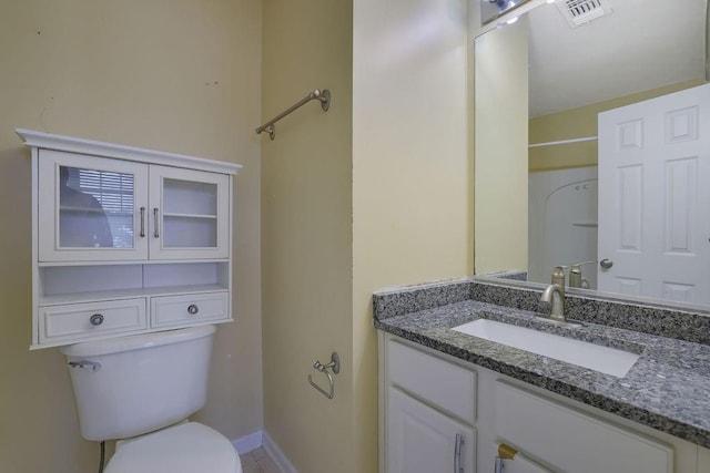 bathroom featuring vanity, toilet, and walk in shower