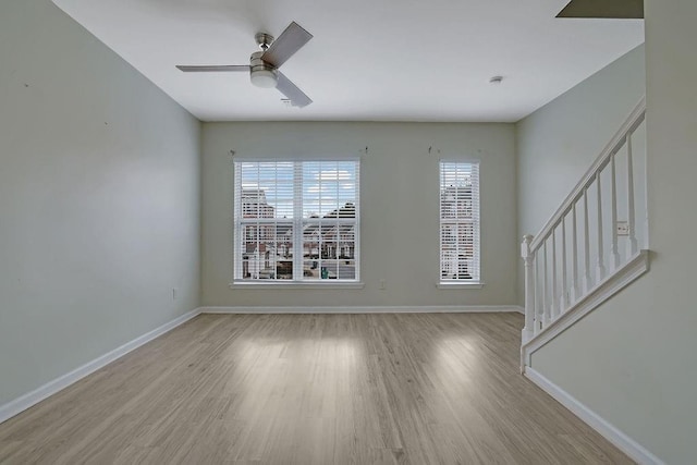 empty room with ceiling fan and light hardwood / wood-style flooring