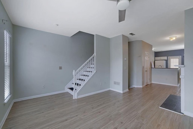 unfurnished living room featuring ceiling fan and light wood-type flooring