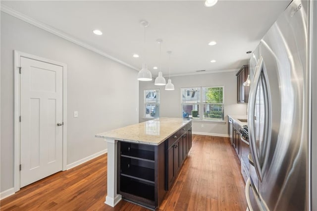 kitchen featuring stainless steel appliances, dark brown cabinets, pendant lighting, and a kitchen island