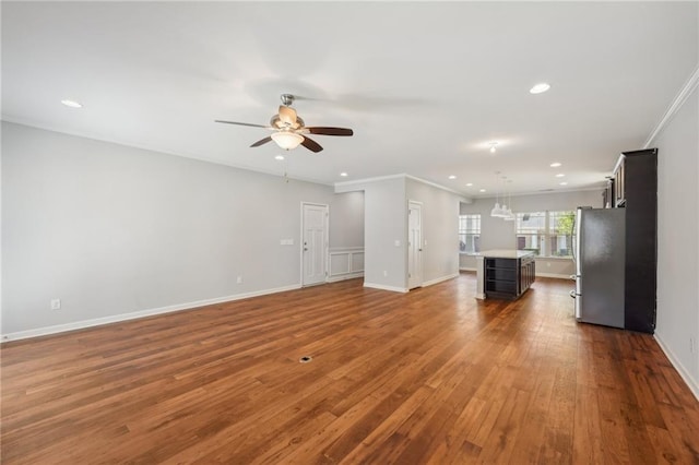 unfurnished living room featuring ceiling fan, hardwood / wood-style flooring, and ornamental molding