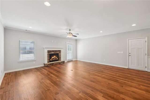 unfurnished living room with ceiling fan, wood-type flooring, and a fireplace