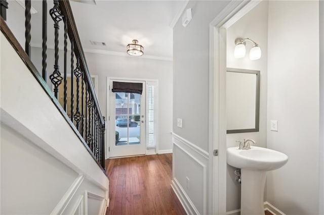 foyer entrance with crown molding, dark hardwood / wood-style floors, and sink