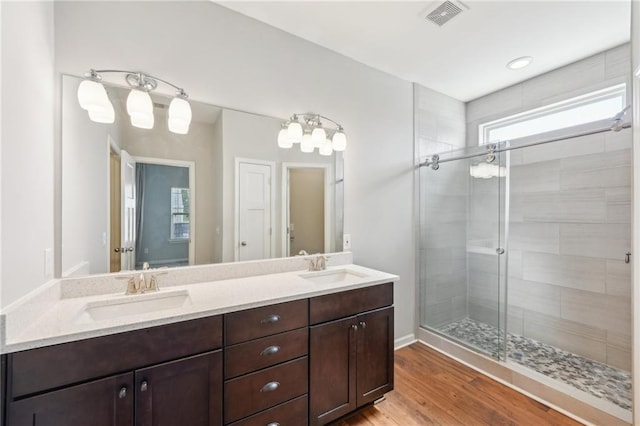 bathroom featuring vanity, hardwood / wood-style flooring, and a shower with shower door