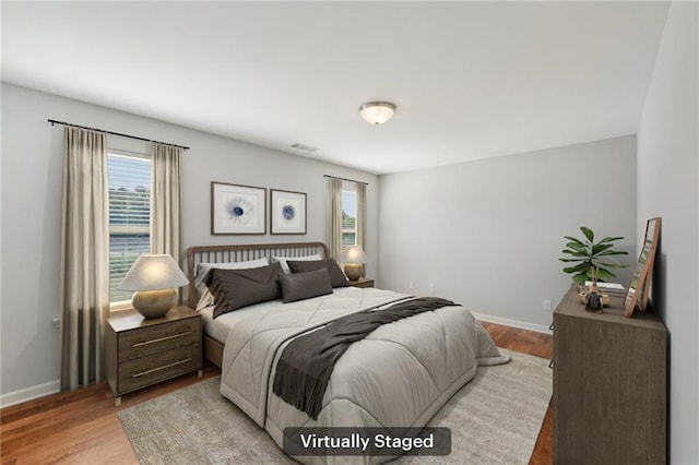 bedroom featuring light hardwood / wood-style flooring and multiple windows